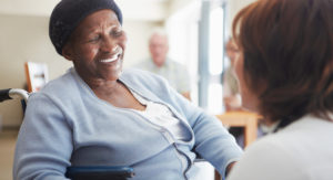 Elderly African American woman looks at caregiver in an adult day center