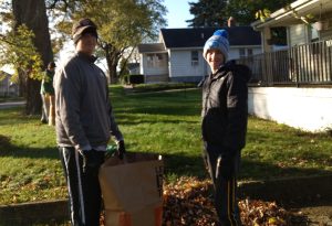 Students from Brother Rice High School help with a fall clean up for a local senior.