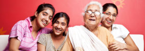 Older woman sits surrounded by three granddaughters