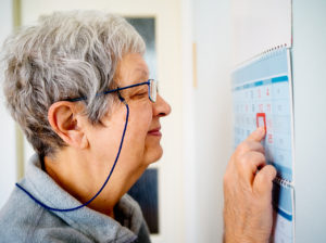Senior woman looking at a highlighted date on a calendar