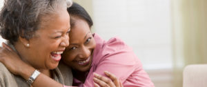 adult daughter hugging elderly mother