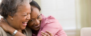 Adult daughter hugging elderly mother.