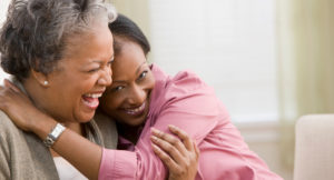 adult daughter hugging elderly mother
