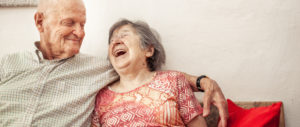 Older couple sitting on couch embracing each other