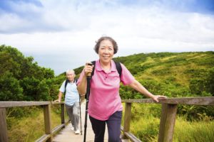 Older asian couple hiking over bridge