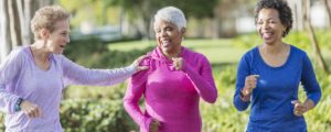 three women in their sixties power walking outside