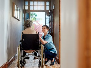 Professional caregiver caring for elderly woman in wheelchair