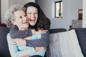 Daughter hugging elderly mother