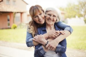 Family caregiver embracing aging mother