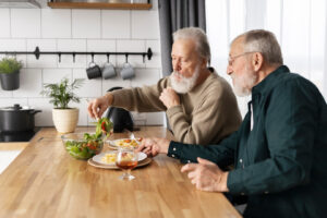 Two older men, eating lunch together.