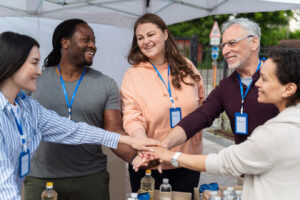 A team of volunteers out at a community event. They are putting their "Hand's In!"