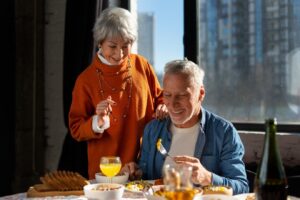 An older man and his wife eating a delightful breakfast.