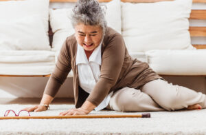 Asian senior woman falling down lying on floor at home alone. Elderly woman pain and hurt from osteoporosis sickness or heart attack. Old adult life insurance with health care and treatment concept