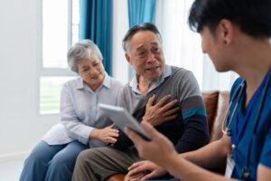 senior asian man consult and discuss medical examination results with physiotherapist at clinic. home caregiver nurse visit retirement patient for health check up recovery process medical service